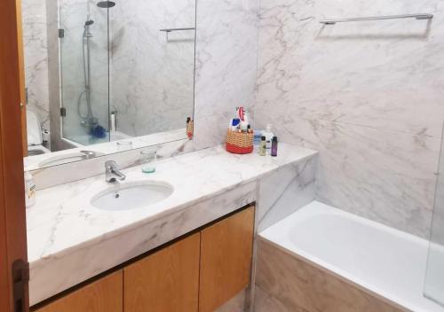 biała łazienka z umywalką i prysznicem w obiekcie Loft station w mieście Guimarães