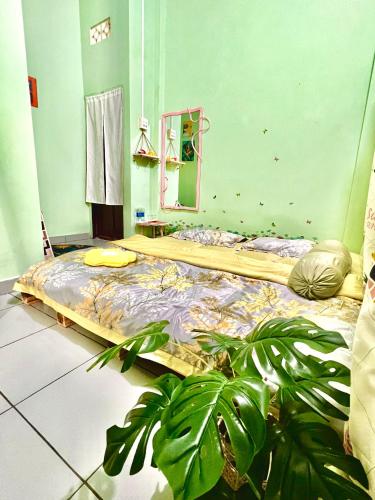 a bedroom with a bed with a mirror and a plant at Homestay YẾN HÒA in Ấp Bình Hưng