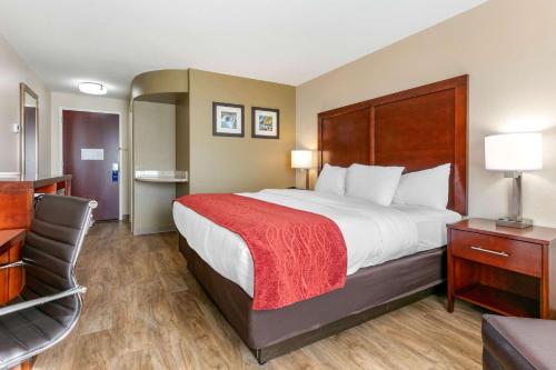 a hotel room with a large bed and a chair at Comfort Inn and Suites Van Buren - Fort Smith in Van Buren