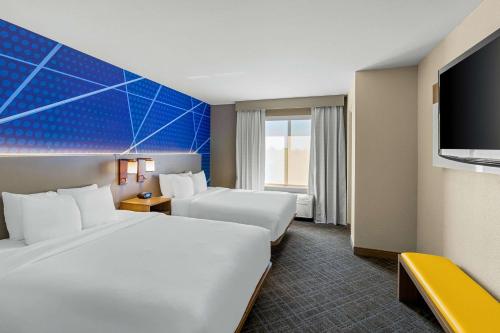 a hotel room with two beds and a flat screen tv at Comfort Suites Vacaville-Napa Valley Area in Vacaville