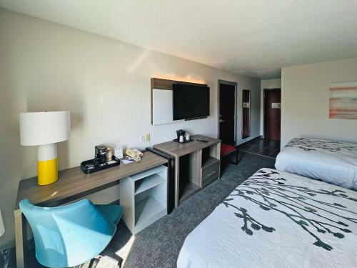 a hotel room with a bed and a desk with a television at Comfort Inn Emporia in Emporia