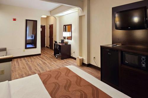 a hotel room with a bed and a flat screen tv at Quality Inn & Suites near St Louis and I-255 in Cahokia