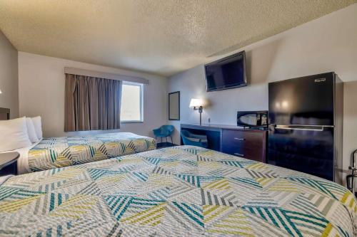 a hotel room with two beds and a television at Motel 6 Stuart, IA in Stuart