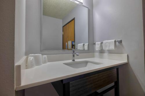 La salle de bains est pourvue d'un lavabo blanc et d'un miroir. dans l'établissement Motel 6 Stuart, Ia, à Stuart