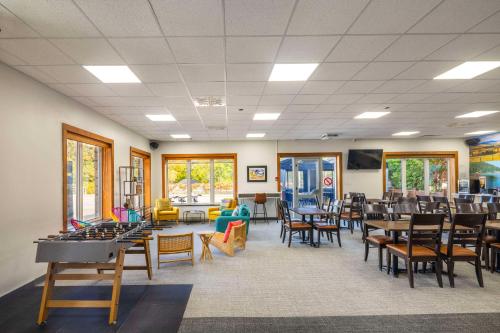 une salle à manger avec des tables et des chaises et une salle avec des tables et des chaises dans l'établissement Clarion Pointe La Malbaie, à La Malbaie