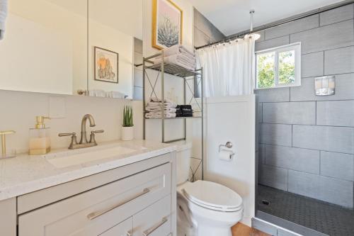 a bathroom with a white toilet and a sink at Mojave Lofi - Bright and Airy home 25 min from Joshua Tree National Park - Hot Tub, Cal-King Beds, Game Room in Yucca Valley