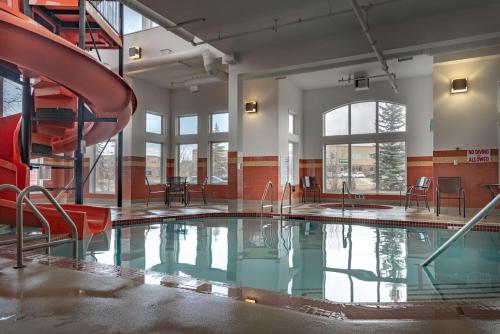 a swimming pool with a slide in a building at Service Plus Inns and Suites Calgary in Calgary