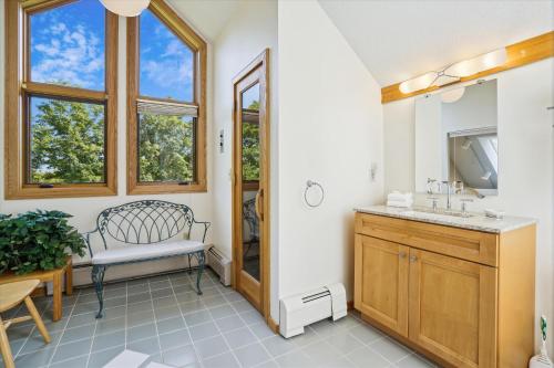 a bathroom with a sink and a bench and a mirror at Highridge J5B Spectacular 1 Bedroom Escape with fireplace, sauna & resort amenities in Killington