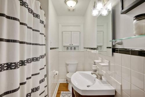 een witte badkamer met een wastafel en een toilet bij Center St Retreat - 1 Block from Downtown! in Apex