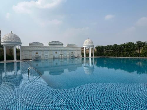 a large swimming pool with a building in the background at Panorama Haven With Swimming Pool in Lucknow