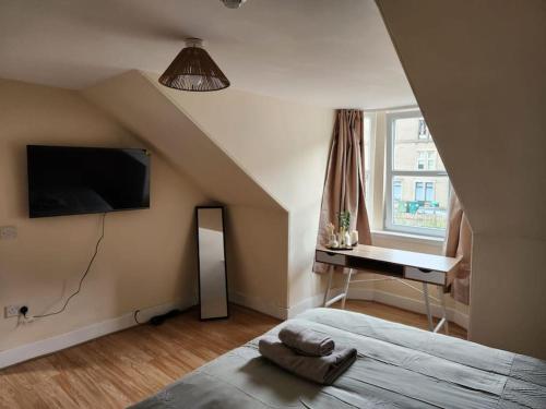 a bedroom with a bed and a desk and a window at West End Dream in Dundee