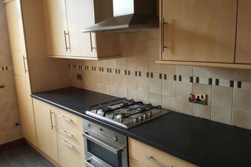 a kitchen with a stove and a black counter top at West End Dream in Dundee
