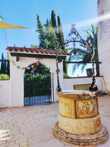 a fountain in front of a building with a gate at Casa con encanto in Corbera de Llobregat