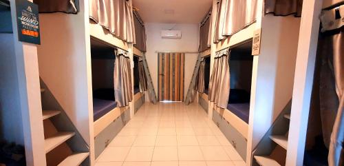 a corridor of a room with beds and a hallway at Tiny Room Hostel in Nusa Penida