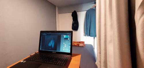 einen Laptop auf einem Tisch im Schlafzimmer in der Unterkunft Tiny Room Hostel in Nusa Penida