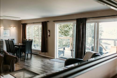 a living room with a table and chairs and windows at Page's Inn on Silva Bay in Gabriola