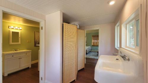 baño con bañera, lavabo y ventana en River Views 2 Homes Sleeps 14 Swim Spa, en Rogue River