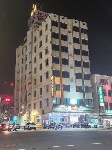 a building at night with cars parked in front of it at Hua Ku Hotel in Tainan