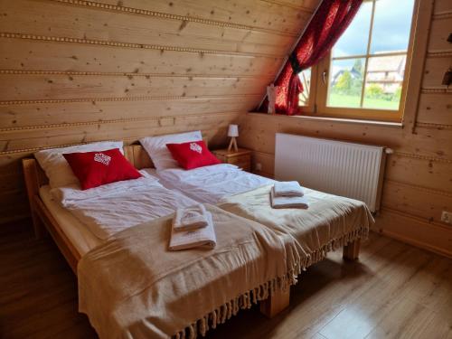 a bedroom with two beds in a log cabin at Góralski Domek Łopatówka z kominkiem i Banią - Jacuzzi! in Murzasichle