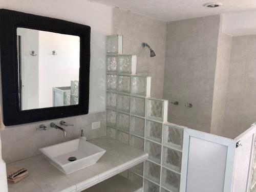 a bathroom with a sink and a mirror at Beautiful Beach Front Pent House in Cancun!!! in Cancún