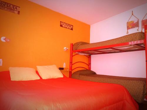 - une chambre avec deux lits superposés et un lit rouge dans l'établissement SPACIO HABITACION APART Baño Privado Estar con microondas y frigobar, à Mendoza