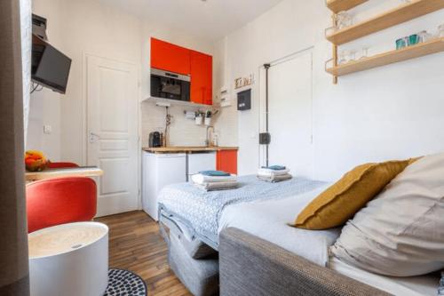 een kleine kamer met een bed en een keuken bij Charmant & Cosy 2 pièces La Defense-Champs Elysees in Puteaux