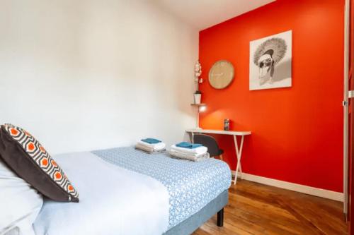 een slaapkamer met een bed en een rode muur bij Charmant & Cosy 2 pièces La Defense-Champs Elysees in Puteaux