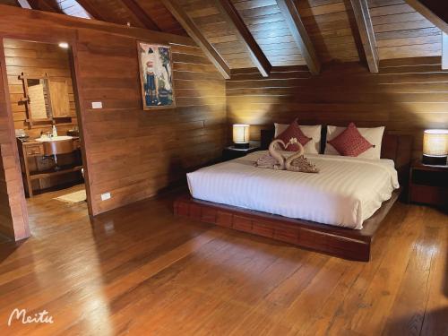 um quarto com uma cama e uma casa de banho com um lavatório em Lantana House em Ban Pa Muang