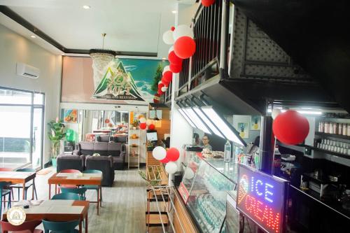un restaurante con globos rojos y blancos colgando del techo en Ziet Hotel, en Mambajao