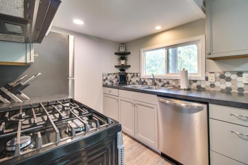 a kitchen with a stove and a sink at Deck and Dock Access Lakefront Grove Cabin! in Grove