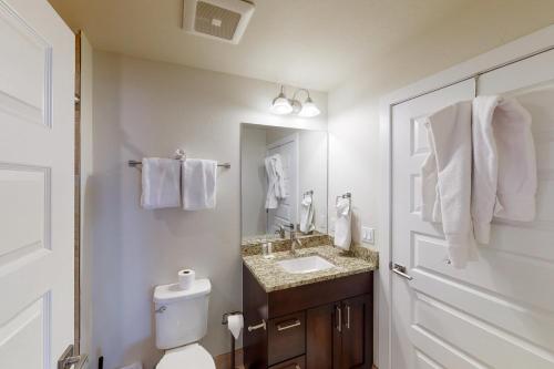 a bathroom with a sink and a toilet and a mirror at La Bonte Townhomes Unit 304 in Dillon