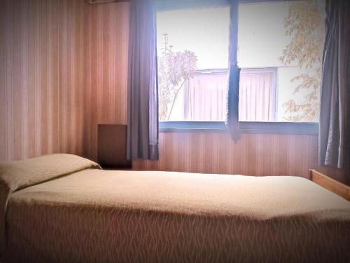 um quarto com uma cama e uma janela em "C" SPACIO HOSTEL - Habitación Compartida por separado para femenino o masculino- em Mendoza