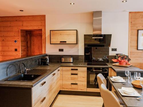 a kitchen with a sink and a table with chairs at Lodge avec bain à remous privatif, piscine, salle de sport et aire de jeux au bord du golf de Chambon - FR-1-582-370 in Le Chambon-sur-Lignon