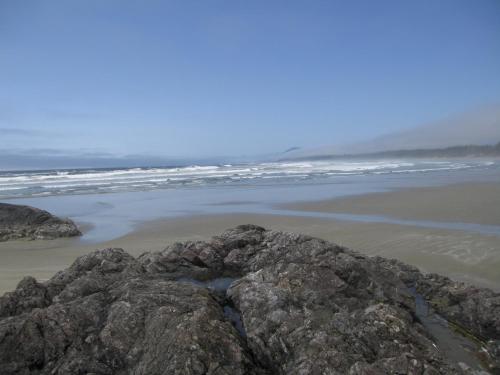 a beach with rocks and the ocean in the background at Forest by the Sea Rentals in Merville