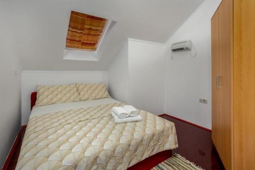 Cette petite chambre comprend un lit avec deux chaussures blanches. dans l'établissement Family friendly house with a swimming pool Blazevci, Gorski kotar - 21038, à Vrbovsko