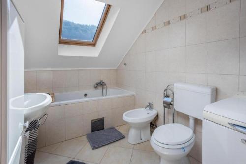 La salle de bains est pourvue de toilettes, d'un lavabo et d'une baignoire. dans l'établissement Family friendly house with a swimming pool Blazevci, Gorski kotar - 21038, à Vrbovsko