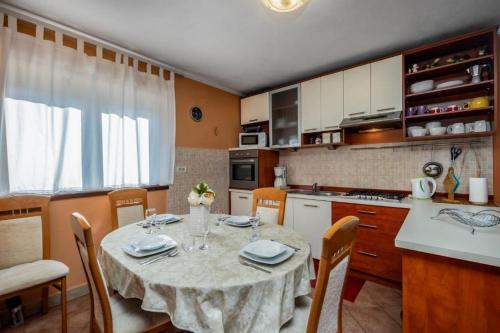 a kitchen with a table and chairs in a kitchen at Family friendly house with a swimming pool Blazevci, Gorski kotar - 21038 in Vrbovsko