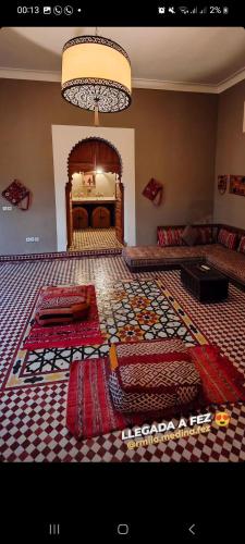 a large living room with a patterned floor at Hostel riad Dar lala sofia in Fez