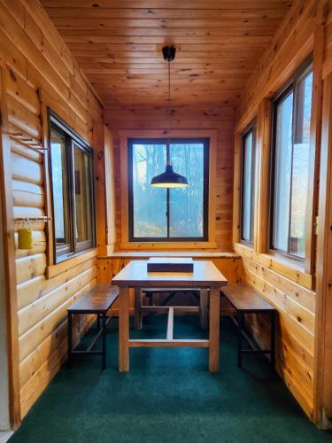 a dining room in a log cabin with a table and benches at Belleayre Lodge in Pine Hill