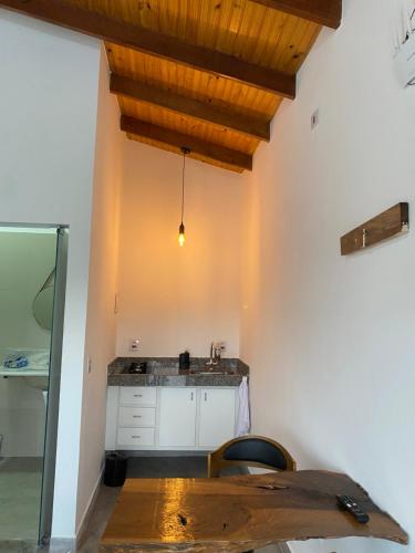 uma cozinha com um lavatório e um tecto de madeira em Chalé Escarpas em Capitólio