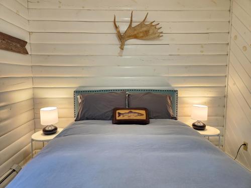 a bedroom with a bed with two lamps on two tables at Belleayre Lodge in Pine Hill