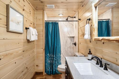 a bathroom with a toilet and a sink at SmokiesBoutiqueCabins would love to host you at Dolly's Cute Cabin! 4 Suites with Private Bathrooms - Hot Tub, Fire Pit, Game Room, Resort Pool open Memorial Day through Labor Day! in Gatlinburg
