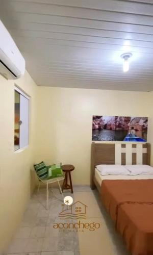 a bedroom with a bed and a table and a chair at Aconchego de Maria in Piranhas