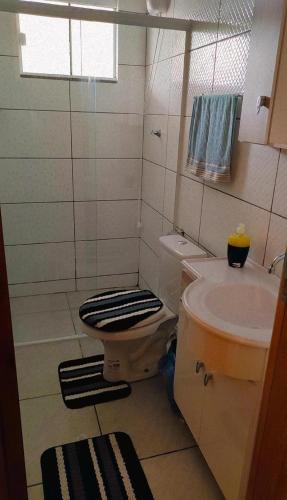a bathroom with a toilet and a sink at Studio Marangoni Hospedagem in Treze Tílias