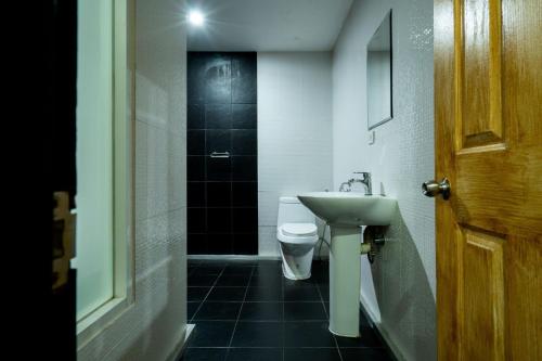 a bathroom with a toilet and a sink and a door at GO INN Sukhumvit-Bts Asoke-Phrom Phong โกอินน์ สุขุมวิท in Bang Kapi