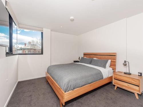 a bedroom with a bed and a large window at City Lifestyle right in the heart of Hobart in Hobart