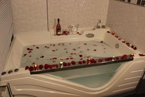 a bath tub filled with red roses and candles at Hostal DRABA in Lima