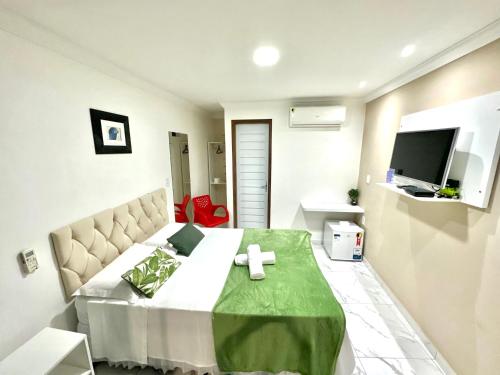 1 dormitorio con 1 cama grande y TV en Pousada Maresia, en Maragogi
