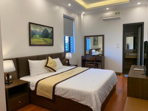 a bedroom with a large bed and a desk at Kim Tuyen Hotel in Ninh Binh