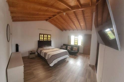 1 dormitorio con 1 cama y TV en una habitación en Finca La Consentida, en Guarne